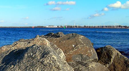 Auf diesem Bild sieht man im Vordergrund Felsen, dahinter verschwommen die Hafeneinfahrt.